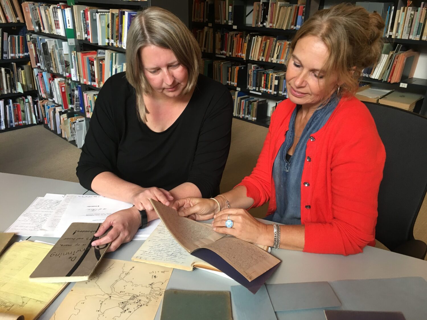 Suzanne Wouda & Annemarie van den Brink bekijken de originele dagboeken in het NIOD